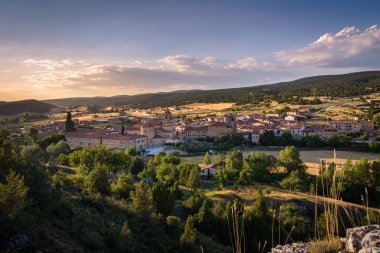 Santo Domingo de Silos 'un şehir manzarası tepenin üstündeki bir kayadan ve şehir merkezindeki Silos Manastırı' ndan gün batımında, Burgos, İspanya