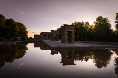 Mısır 'ın Debod Tapınağı bir bahar günü Madrid, İspanya' da gün batımında göletin sularına yansıdı.