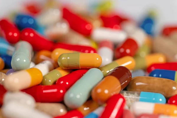 Many colorful capsules and tablets in a closeup