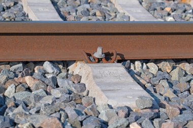 Çakıl taşlı yatakta, yakın plan bir tren yolu.