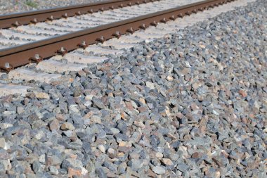 Çakıl taşlı yatakta, yakın plan bir tren yolu.