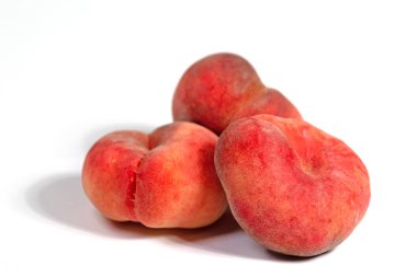 Düz şeftaliler beyaz arkaplanda izole edilmiş