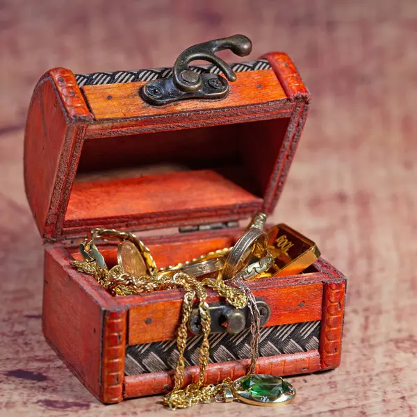 Gold jewelry and gold coins in the wooden casket