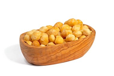 Tahta bir kasede beyaz arka planda Macadamia fındıkları