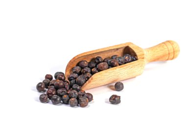 Baharat küreğindeki ardıç meyveleri beyaz arka planda