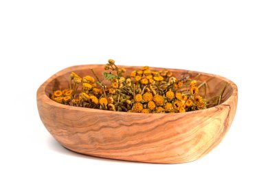 Ahşap bir kasede, beyaz bir arka planda kurumuş tansi.