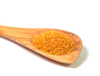 Kahverengi kamış şekeri tahta kaşıkta beyaz arka planda