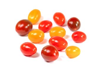 Beyaz arka planda çeşitli mini domatesler