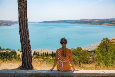Su deposu manzaralı bir kız kaldırımda dikiliyor. Yüksek kalite fotoğraf