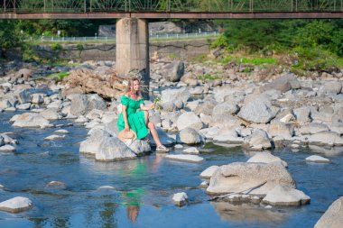 Şapkalı bir kız kayalıklarda oturuyor. Yüksek kalite fotoğraf