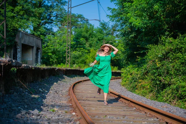 Yeşil Elbiseli Genç Bir Kadın Demiryolu Boyunca Koşuyor Yüksek Kalite — Stok fotoğraf