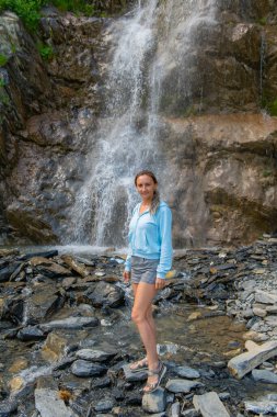 Mavili kız şelalenin arka planında. Yüksek kalite fotoğraf