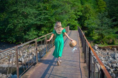 Yeşil bir elbise ve şapkayla güvertede yürür. Yüksek kalite fotoğraf