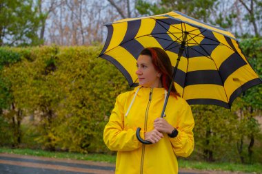 a serious woman with an umbrella on the street. High quality photo