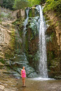 bridge waterfall one girl in pink dress stands. High quality photo