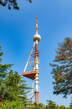 TV tower in the city of Tbilisi on the background of green trees. High quality photo