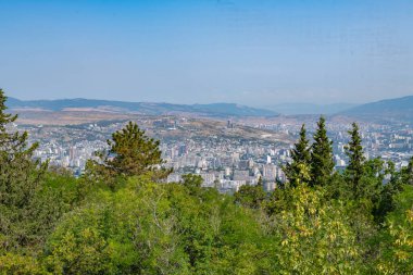 view from the top of the mountain to the city of green trees. High quality photo