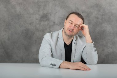 Kapalı gözler ve düşünceli olmak gri takım elbiseli bir adamdır. Yüksek kalite fotoğraf