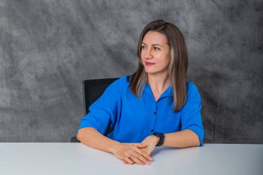 Mavi gömlekli düşünceli bir kadın oturuyor. Yüksek kalite fotoğraf