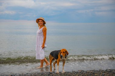 Şapkalı, beyaz elbiseli ve köpekli genç kız. Yüksek kalite fotoğraf