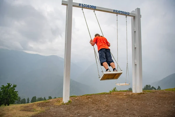 Boundless Energy: Man on Swings in Orange T-Shirt. High quality photo