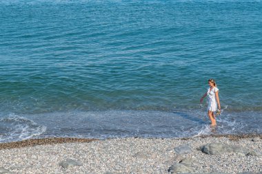 Taşlar ve Huzur: Mavi Deniz 'in yanındaki beyaz elbise. Yüksek kalite fotoğraf