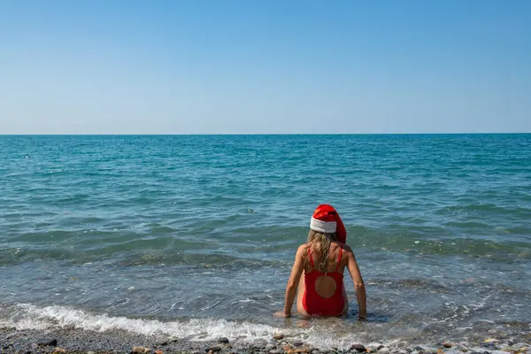 Noel Baba Deniz Kıyısı Şelalesi: Kırmızı mayo giyen kız. Yüksek kalite fotoğraf