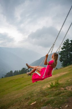 Garip bir salıncak ve yaz rüyalarında pembe elbiseli bir kız salıncakta sallanıyor. Yüksek kalite fotoğraf
