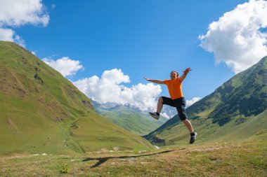 Bir adam canlı turuncu tişörtü ile zıplıyor. Yüksek kalite fotoğraf