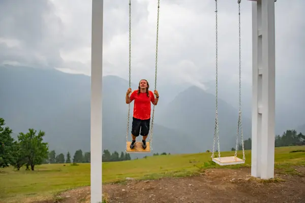 Orange T-Shirt Ascension: Man on a Swing. High quality photo