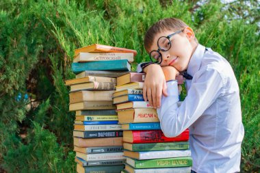 Tired student in glasses sitting among books. High quality photo