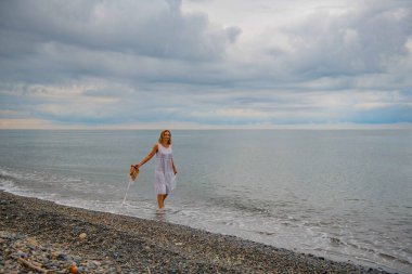 Şapkalı bir kadın deniz kıyısında yürüyor. Yüksek kalite fotoğraf