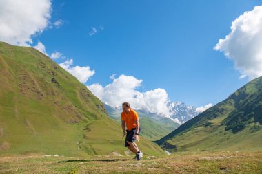 Yükseltilmiş Maceralar: Bir Adam Yeşil Dağlara ve Bulutlara Karşı Atlıyor. Yüksek kalite fotoğraf