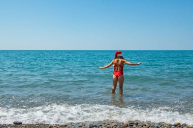 Tropik Noel Baba Şelalesi: Deniz kenarındaki kırmızı mayo. Yüksek kalite fotoğraf