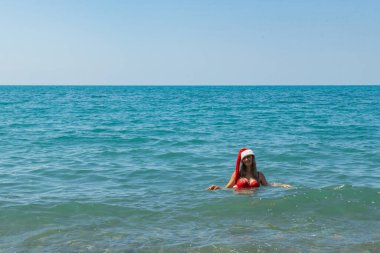 Kıyıdaki Noel Baba Şapkası: Kırmızı Mayo Okyanus Macerası. Yüksek kalite fotoğraf