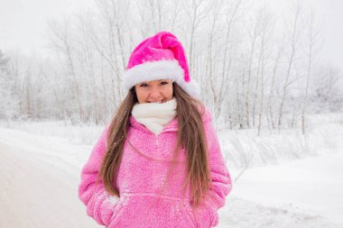 Kış ormanında pembe Noel şapkalı bir kız. Yüksek kalite fotoğraf
