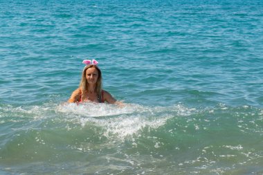 Deniz kıyısı Santa Splash: kırmızı mayo ve şenlik şapkası. Yüksek kalite fotoğraf