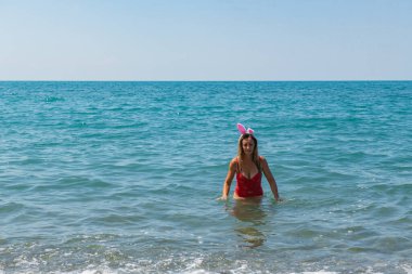 Sahilde Noel Eğlencesi: Noel Baba Şapkalı Kırmızı Mayolu Kız. Yüksek kalite fotoğraf