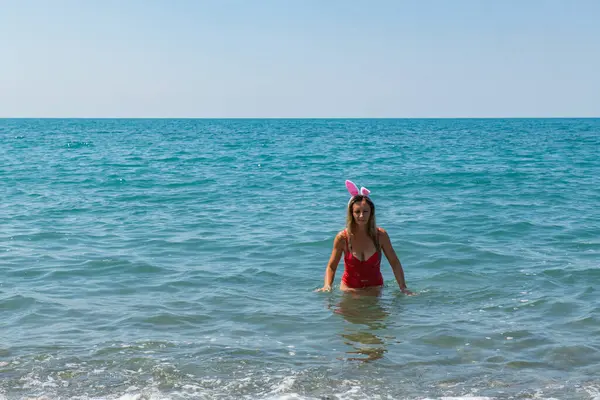 Sahilde Noel Eğlencesi: Noel Baba Şapkalı Kırmızı Mayolu Kız. Yüksek kalite fotoğraf