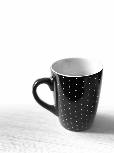 Tahta yüzeyinde Beyaz Noktalı Siyah Kupa Minimalist Kafe natürmort