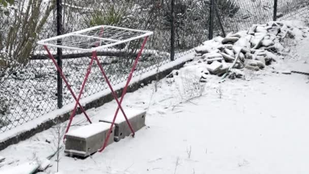 安静的冬日 雪地覆盖了郊区后院的户外晾衣绳和木柴堆 — 图库视频影像