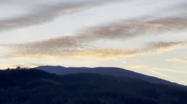 Günbatımı siluetleri Guebwiller 'ın üzerinde Büyük Ballon Tepesi Vosges Dağlarında beliriyor