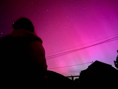 Mayıs 2024 'teki Güneş patlaması sırasında Fransa' da Olağanüstü Pembe Aurora Borealis Altında Siluetli Gözlemci