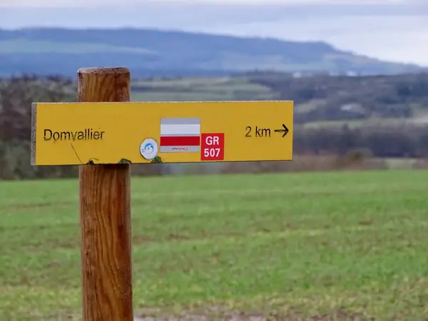 Thiraucourt, Fransa - 24 Aralık 2024: GR507 Vosges, Grand Est, Fransa 'da Bulutlu bir günde Domvallier' e Giden Sarı Yürüyüş Yolu İşareti
