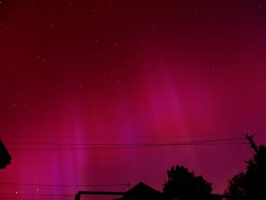 Guebwiller, France - May 10 2024 : Stunning Aurora Borealis Display Over Europe with Vibrant Red and Purple Hues Illuminating the Night Sky clipart