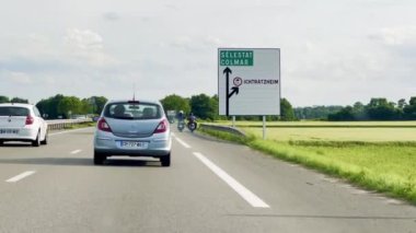Ichtratzheim, Fransa - 6 Haziran 2024: Bas-Rhin, Alsace 'de Slestat, Colmar ve Ichtratzheim için Yol İşareti Yönetmeliği ile D83 üzerinde arabalar ve motosikletler
