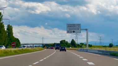 Selestat, Fransa - 6 Haziran 2024: Bas-Rhin, Alsace 'deki Fransız N83 otoyolunun manzarası, Scherwiller, Dambach la Ville ve Ebersheim' in bulutlu gökyüzü altındaki araçları için yol işaretleri