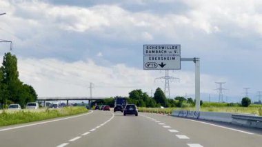 Selestat, Fransa - 6 Haziran 2024: Bas-Rhin, Alsace 'deki Fransız N83 otoyolunun manzarası, Scherwiller, Dambach la Ville ve Ebersheim' in bulutlu gökyüzü altındaki araçları için yol işaretleri