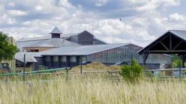 Metal çatılı kırsal sanayi kompleksi ve Bulutlu Gök Altında Ahır Yapıları, Tarım Binaları Üzerinde Uçan Kuş Sürüsü