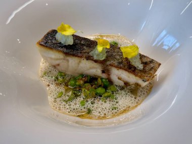 Gourmet Aşçılık Sanatında Kızarmış Balığın Zarif Güzel Yemek Sunumu Kıtır Deri, Yenilebilir Çiçekler ve Köpüklü Çorba